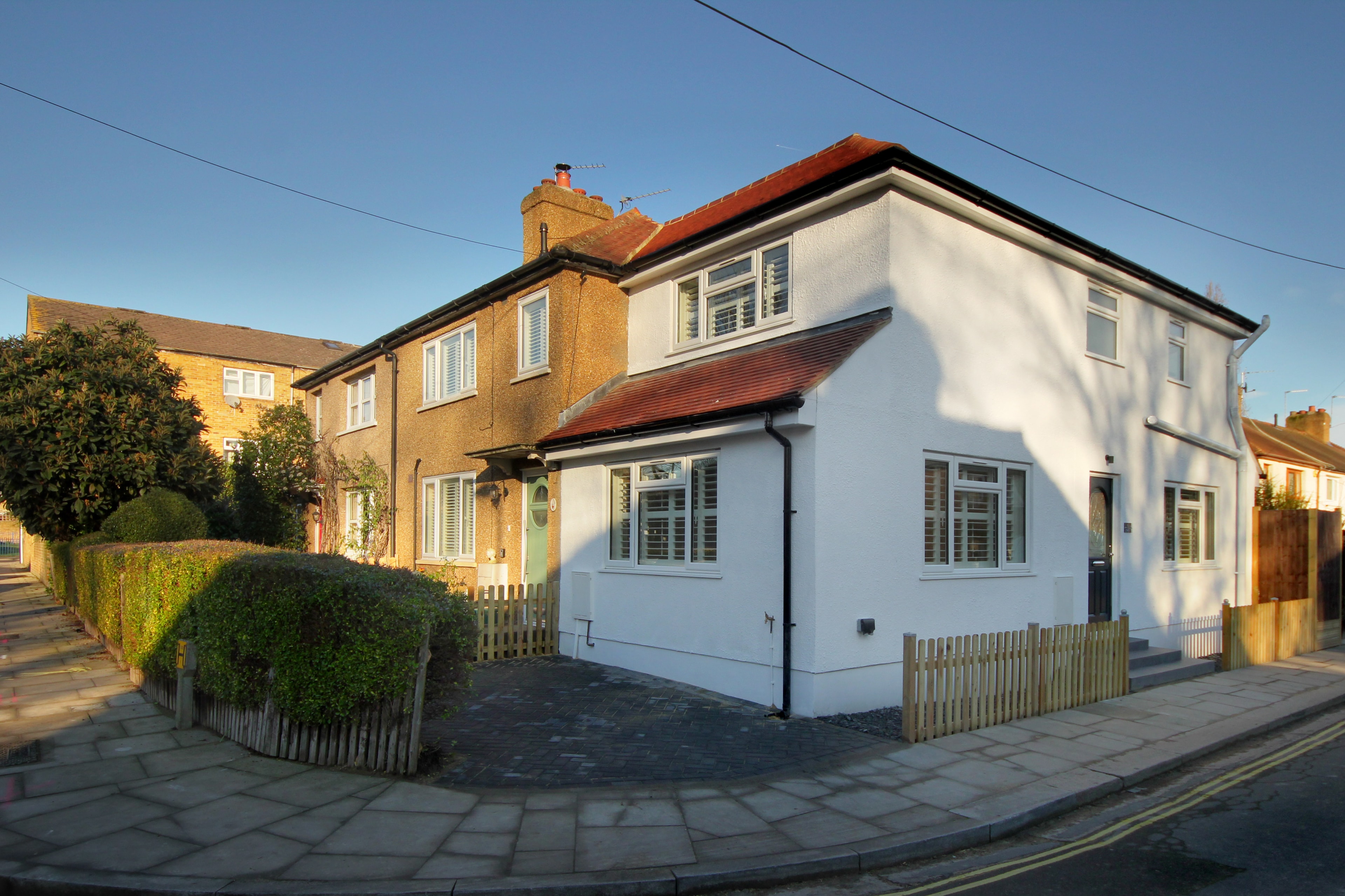 Chilton Avenue — completed corner elevation showing full extent of the redesigned property with white render and new landscaping