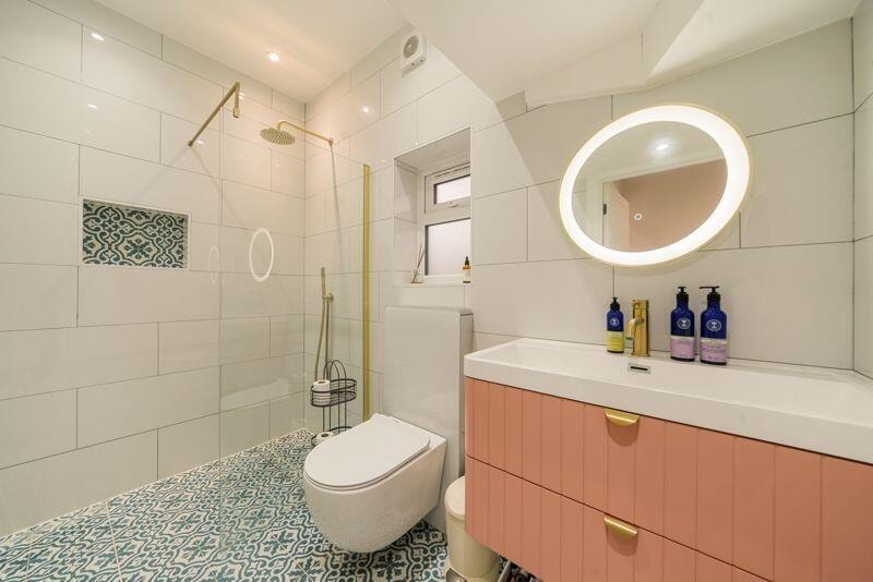 Kitchen detail with teal cabinetry, marble splashback and copper tap