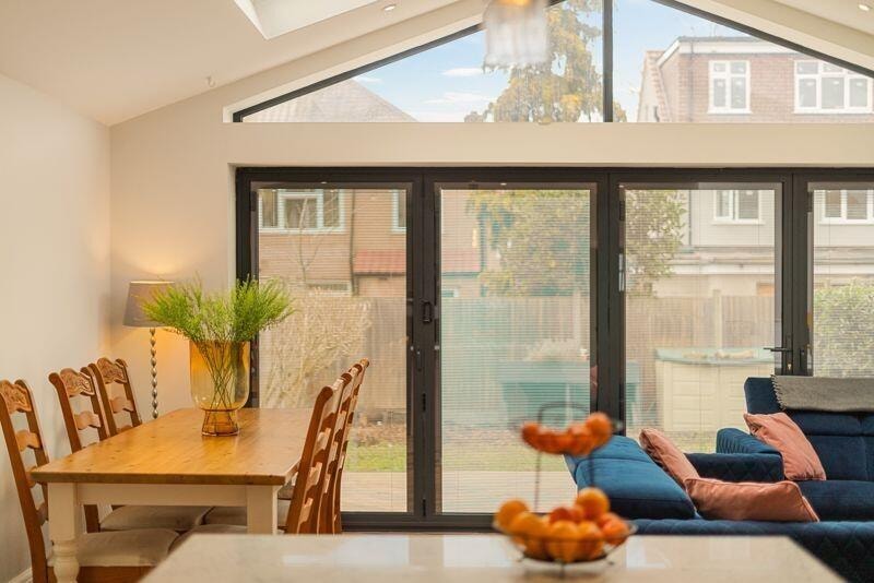 Open-plan living and dining area with bifold doors to garden
