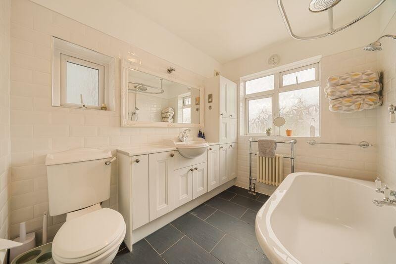 Classic bathroom with freestanding bath and white cabinetry