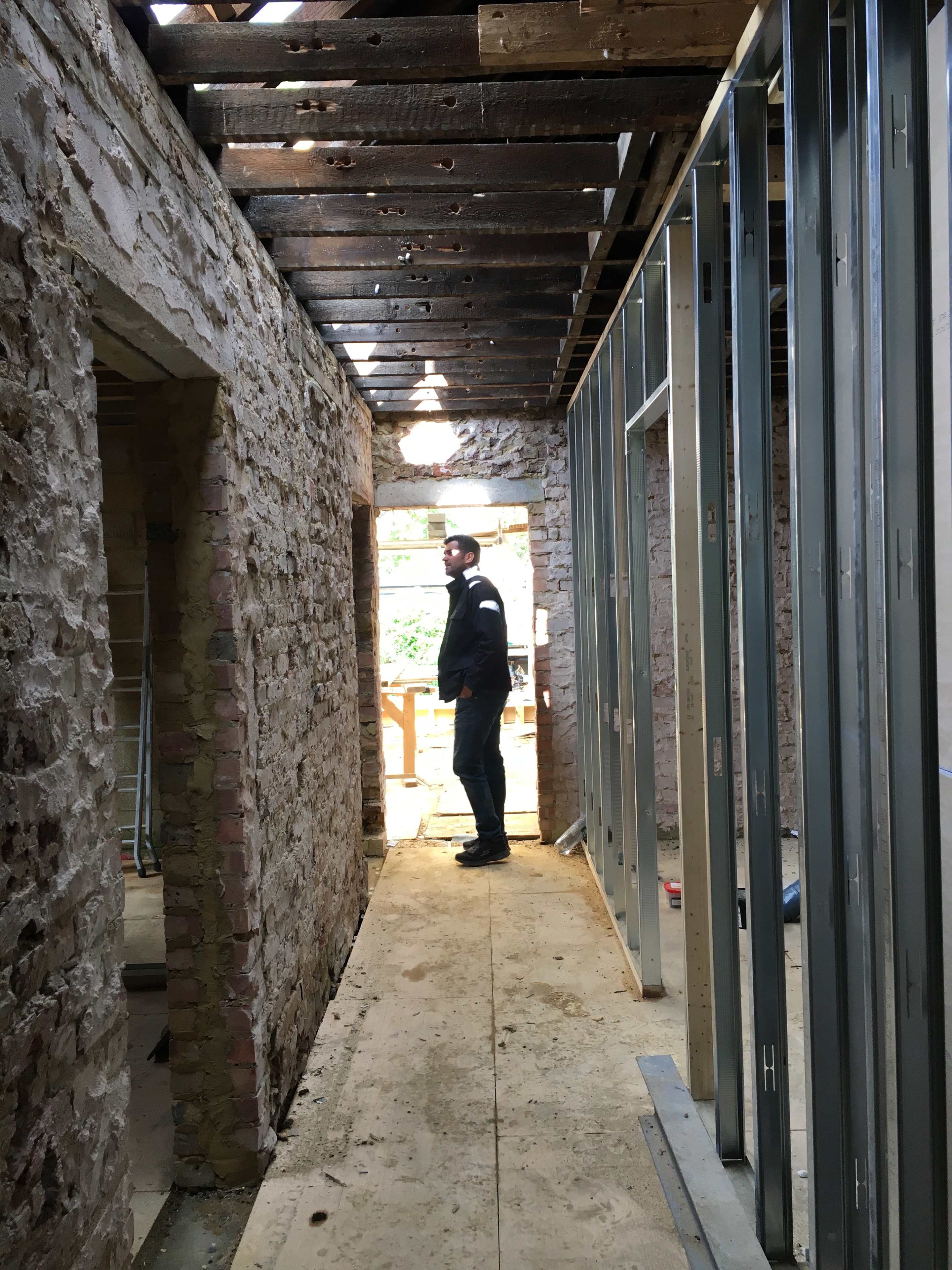 Gordon Road Ealing — interior steel frame and exposed brick walls during conversion, worker visible in background