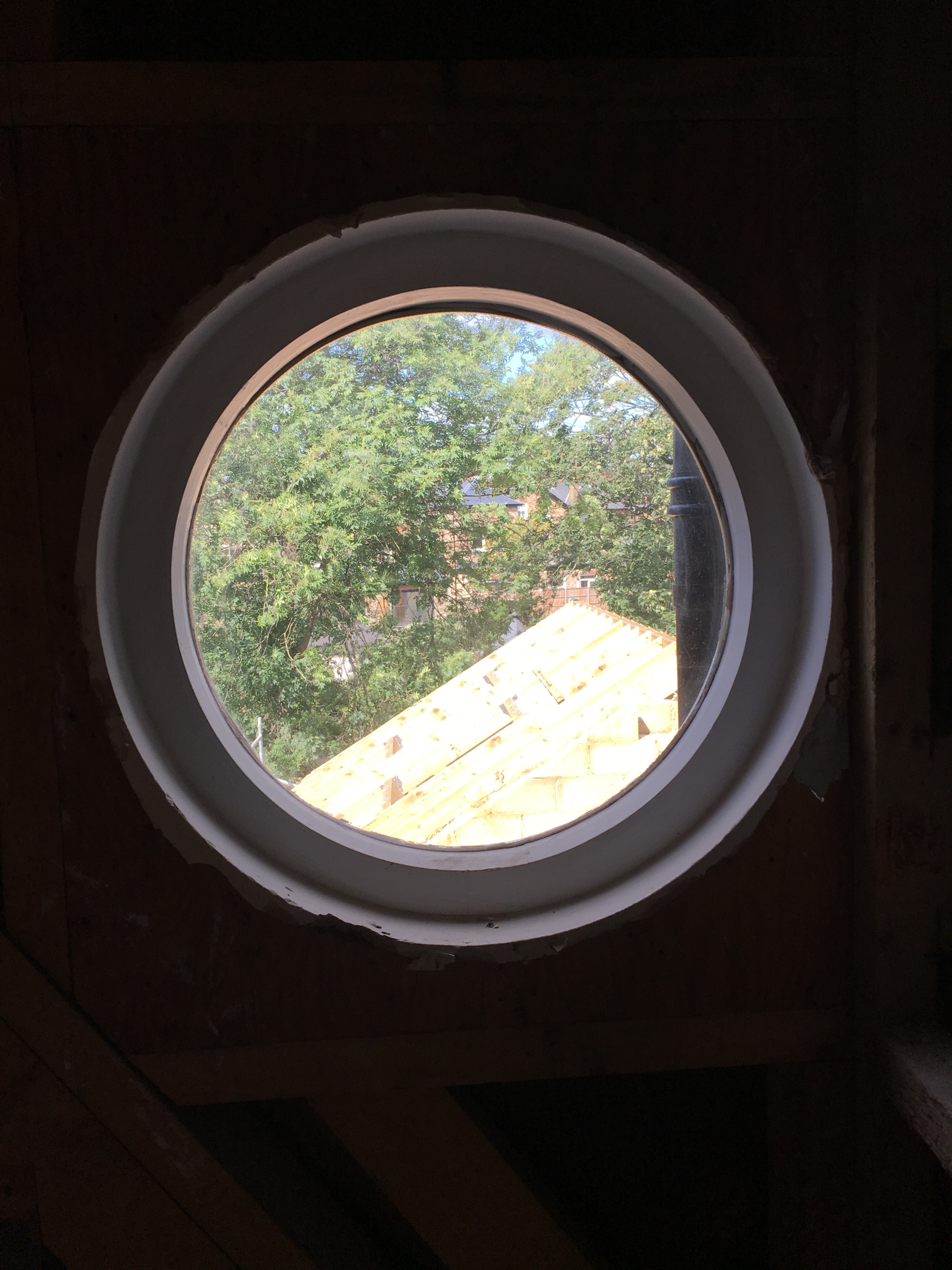 Gordon Road Ealing — circular porthole window looking out to the rear garden and neighbouring properties