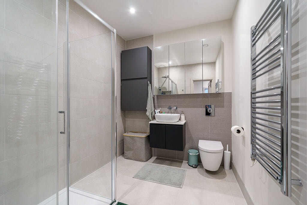 Modern bathroom with walk-in shower enclosure and heated towel rail