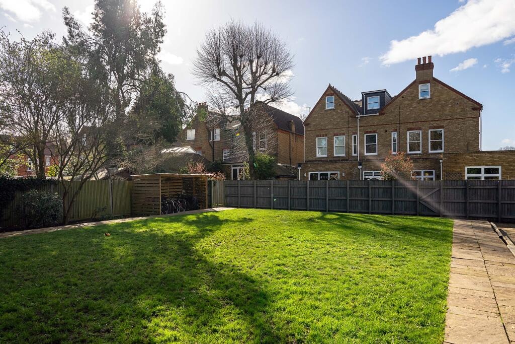 Rear garden with lawn and Victorian houses beyond