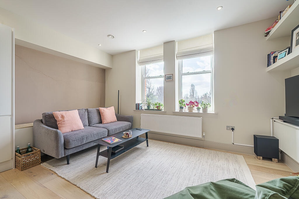 Living room with grey sofa and park-facing sash windows
