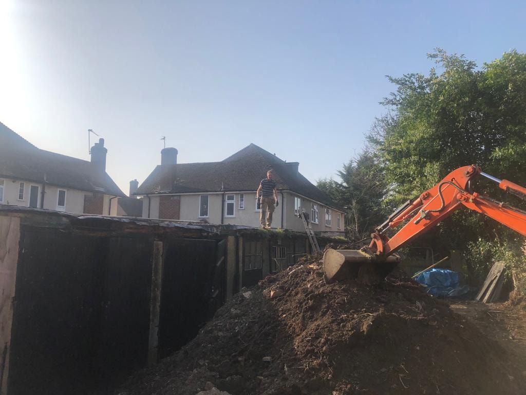 Harrow Road — demolition of existing garage site with orange excavator clearing the plot