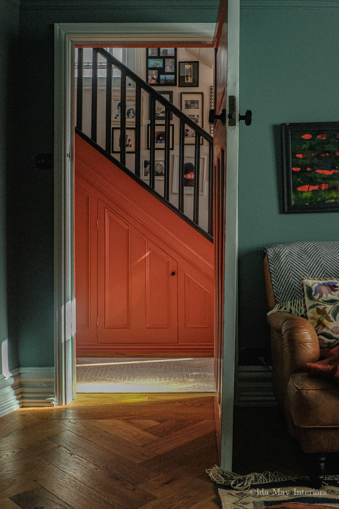 Love Lane — hallway view through to staircase with terracotta painted panelling and gallery wall