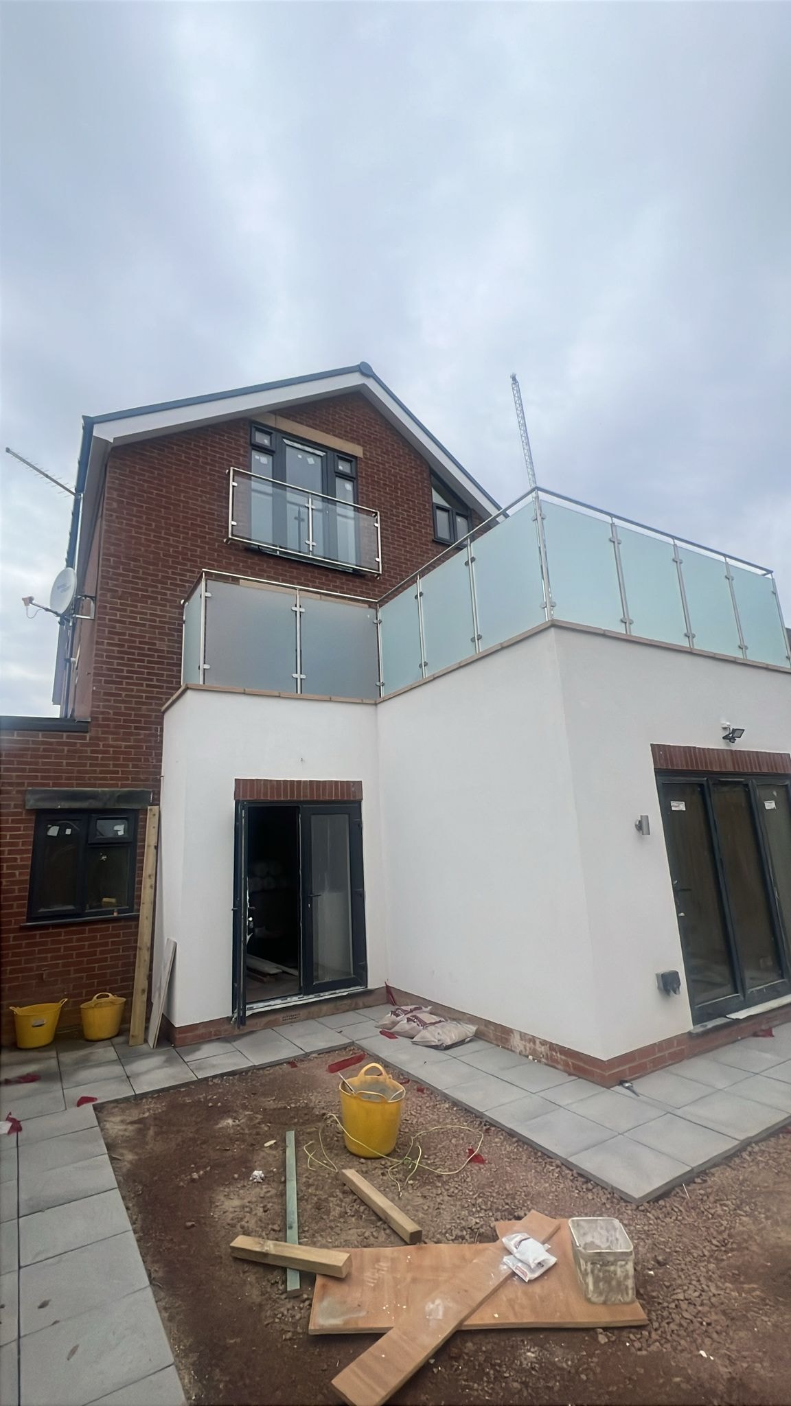 Scouts Hall — rear elevation under construction showing glass balustrades and render panels