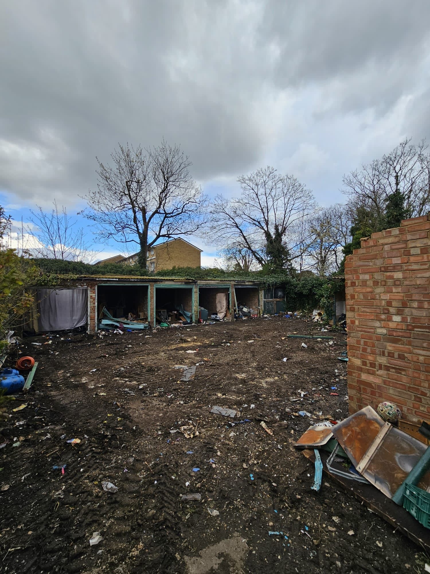 Station Road — existing derelict garage site before development, open bays with debris