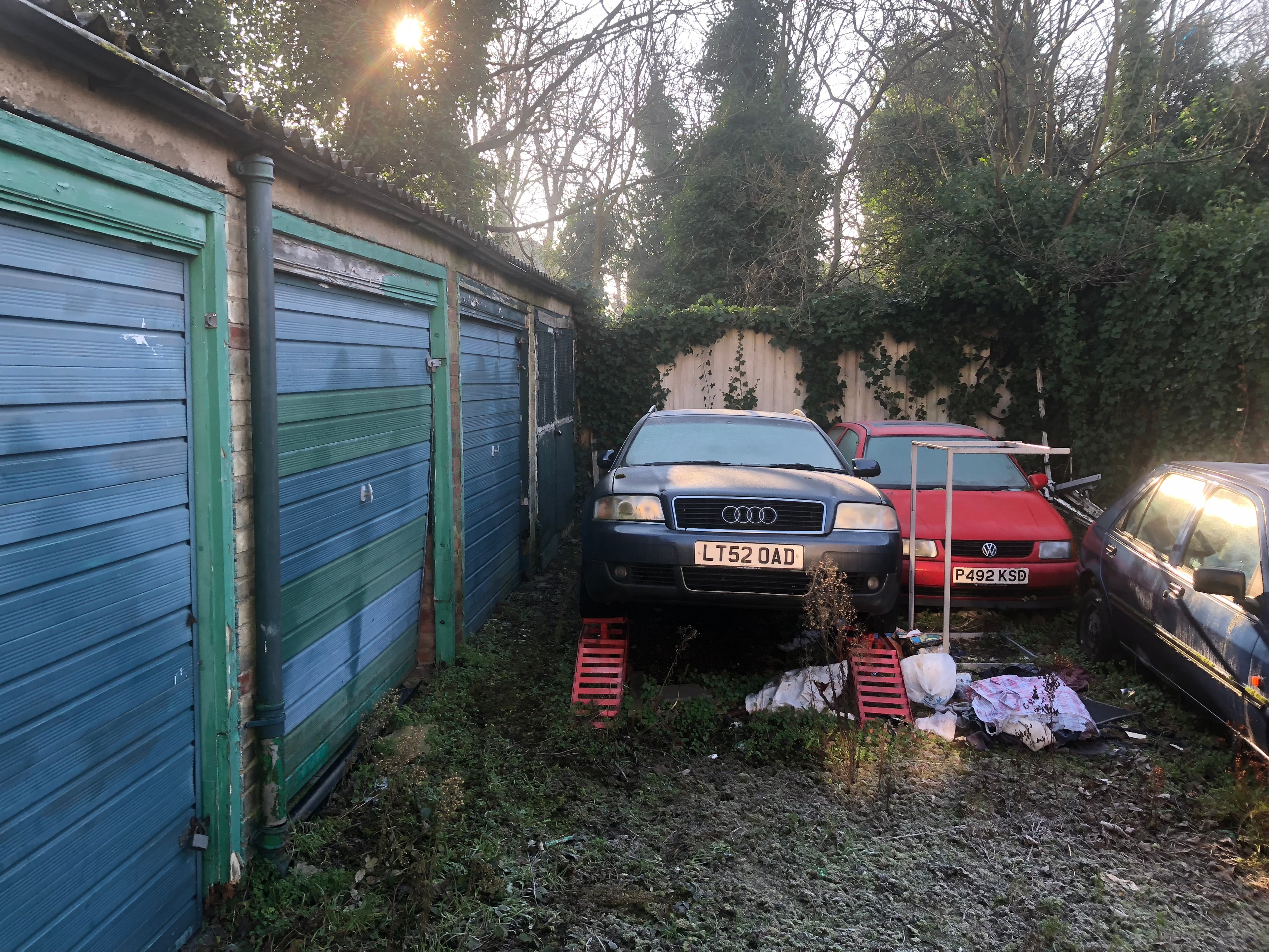 Station Road — existing garage site at dusk with abandoned vehicles