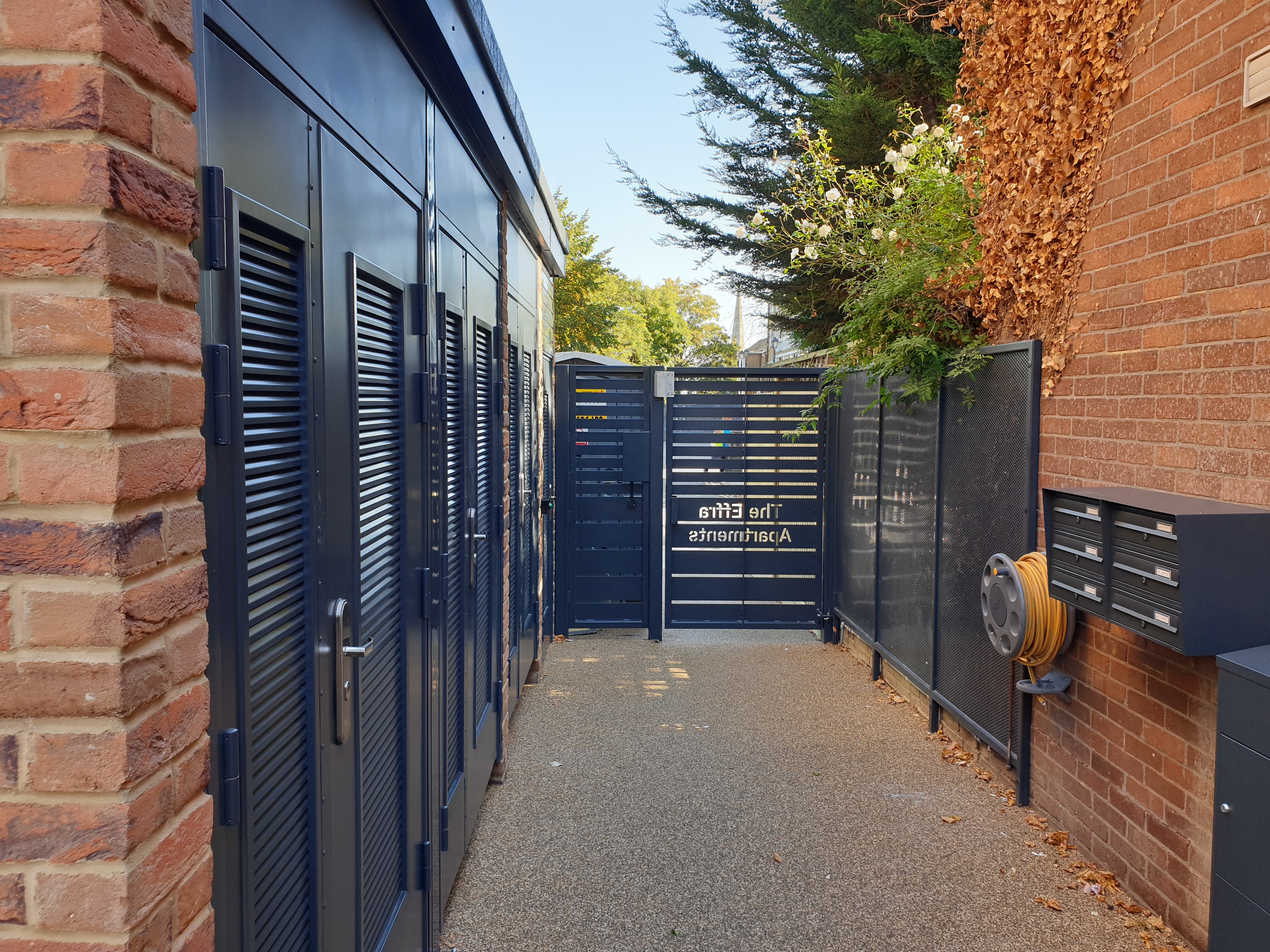 Upper Tulse Hill — completed building showing perforated metal screening and brick facade with louvred storage units