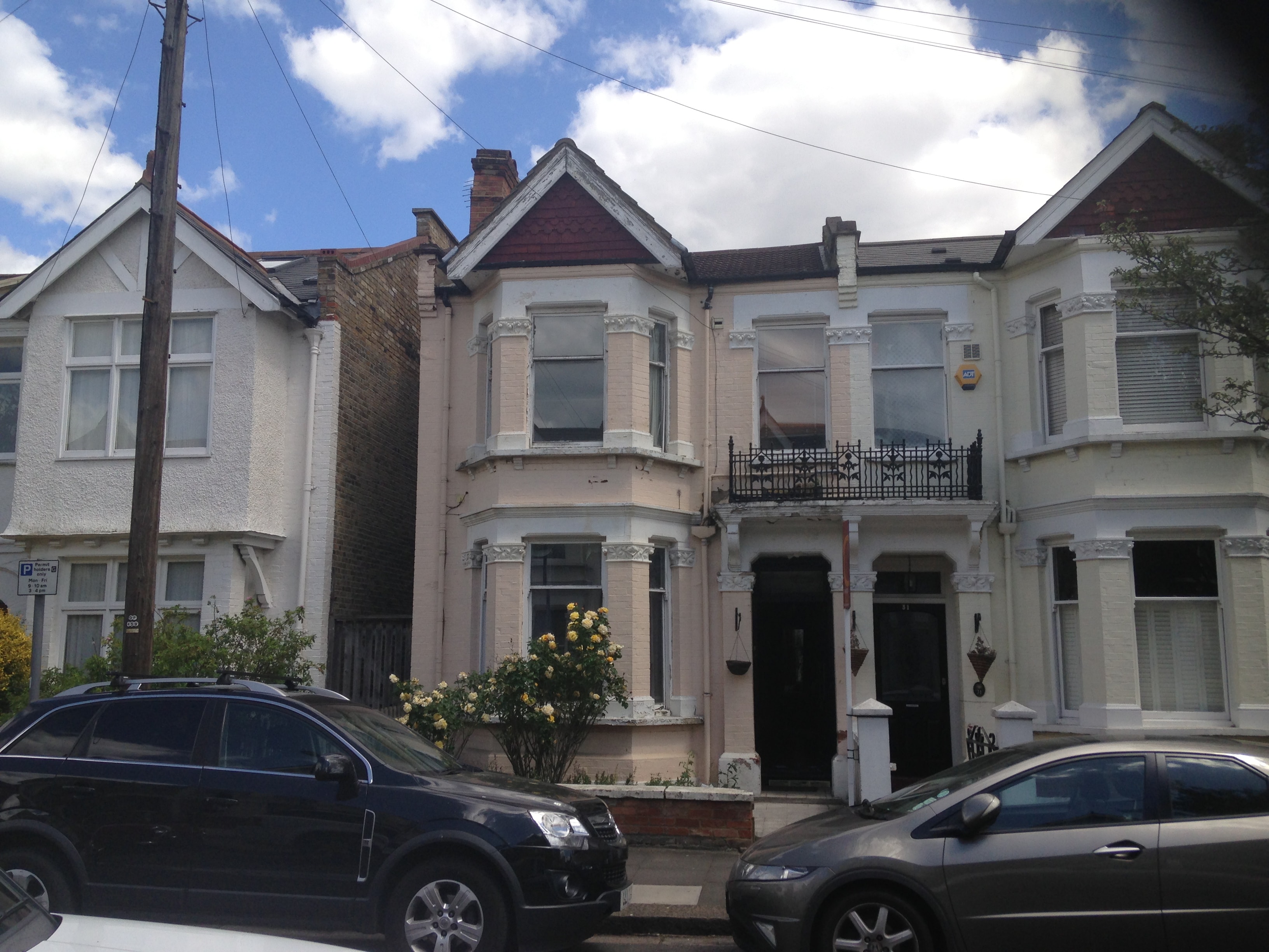 Original front elevation — painted render, bay windows and black door before conversion