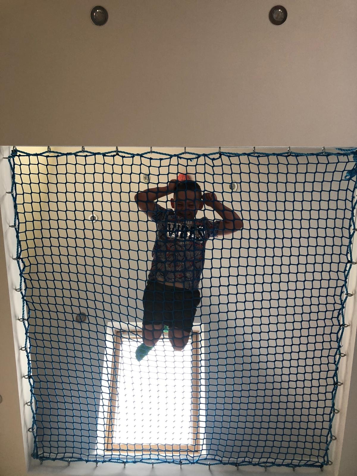 Child playing on loft safety net