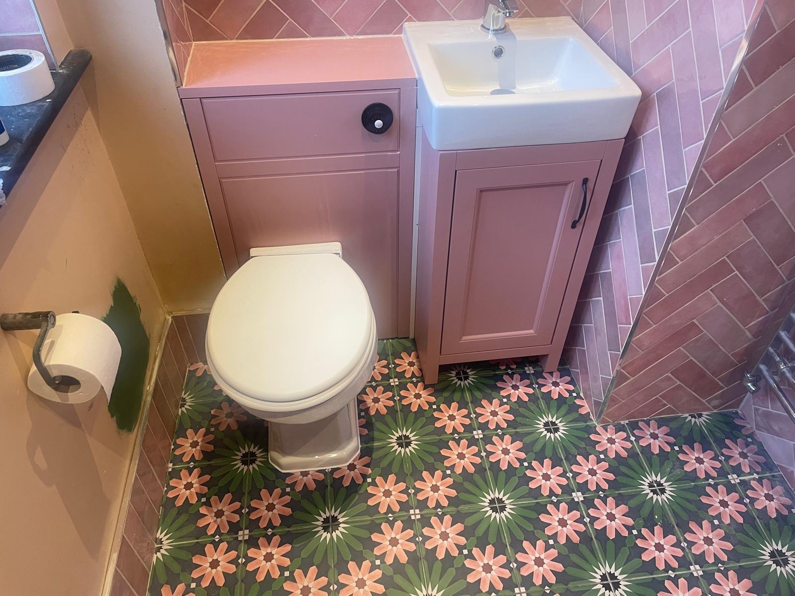 Bathroom with pink vanity and decorative floor tiles